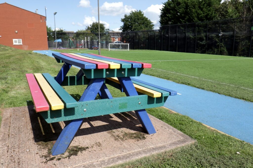 multi coloured bench pictures next to sports field