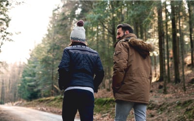 man and teen walking in the forest